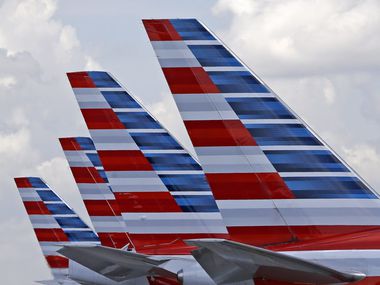  This 2015 photo shows the tails of four American Airlines planes parked at Miami International Airport. 