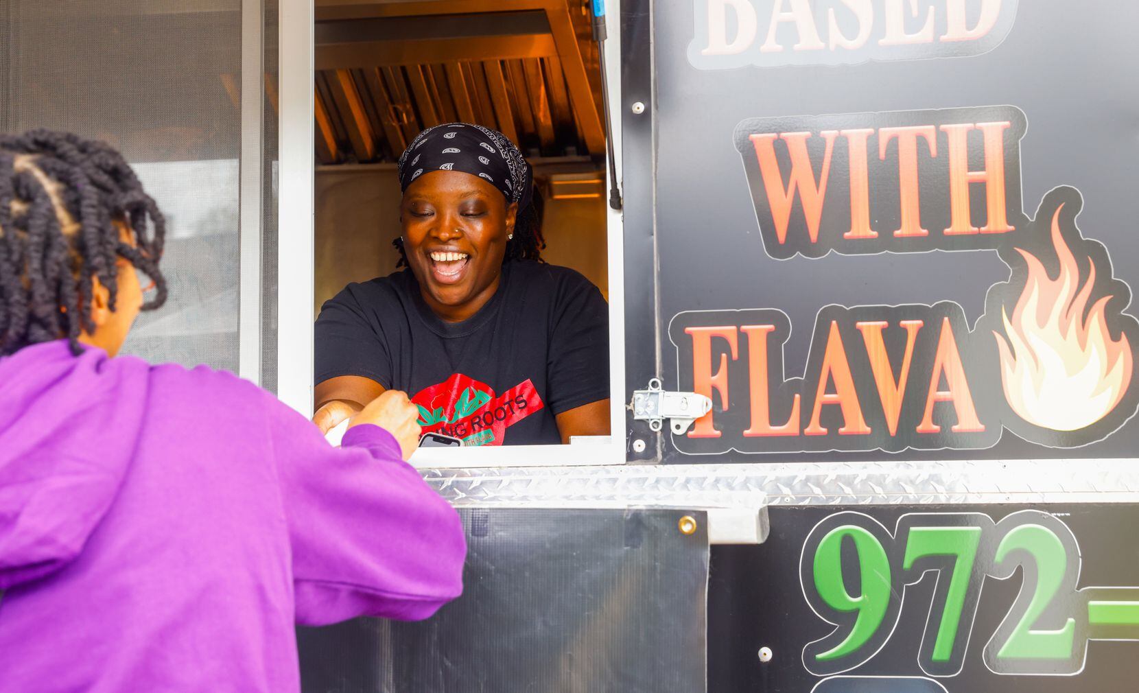 Keke Samba (right) laughs as she takes an order from Zoe Clark from the window of Samba’s...