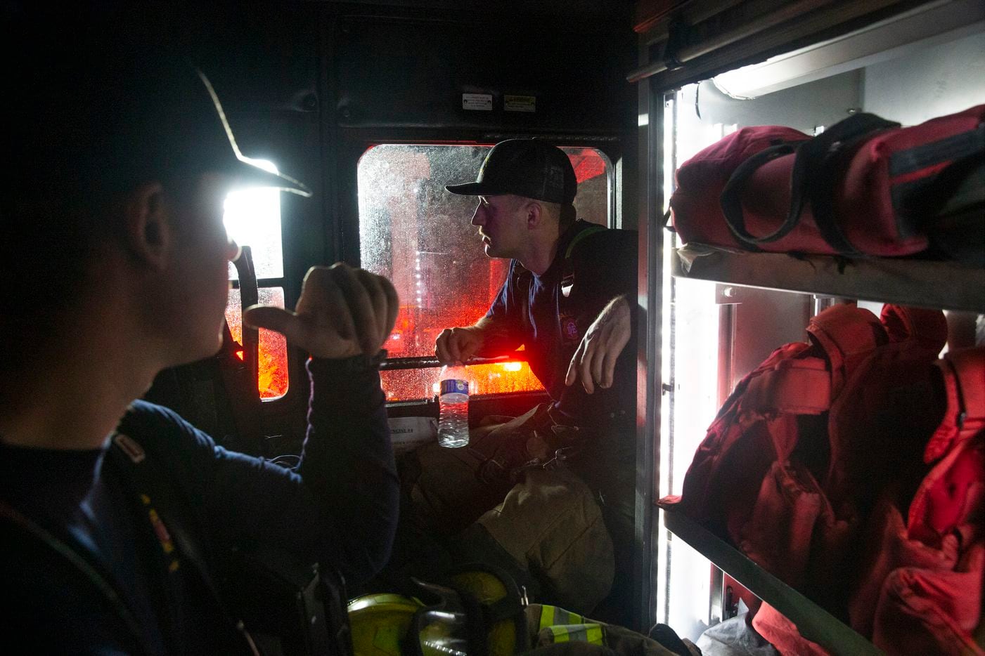 Dallas firefighters Chaz Ponder (right) and Josh Hamm wait out a second storm in Engine 43 a few hours after a tornado hit parts of northern Dallas on Sunday, Oct. 20, 2019.
