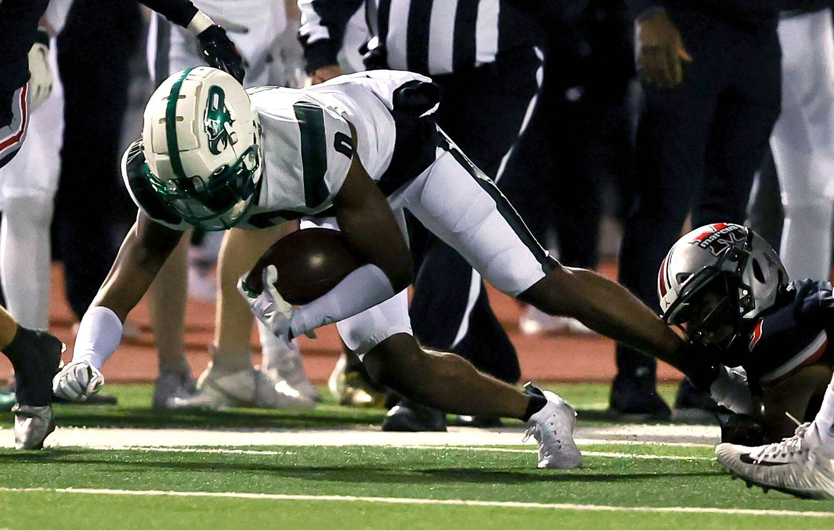 Prosper wide receiver Tyler Bailey (0) is ankle tacked by Flower Mound Marcus defensive back...