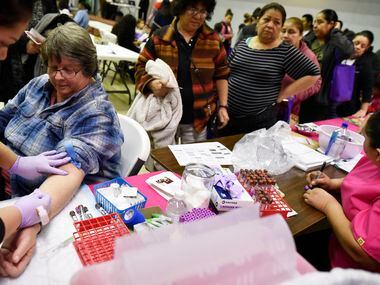 Sherry Boyd, left, had her blood collected for free lab tests during a health fair in Dallas last year. Dallas County scores low on many measures related to health, including access to care, and that's compounded by challenges in education, jobs and other socioeconomic factors.