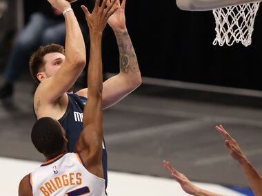 Dallas Mavericks guard Luka Doncic (77) pulls up for a shot in front of Phoenix Suns forward...