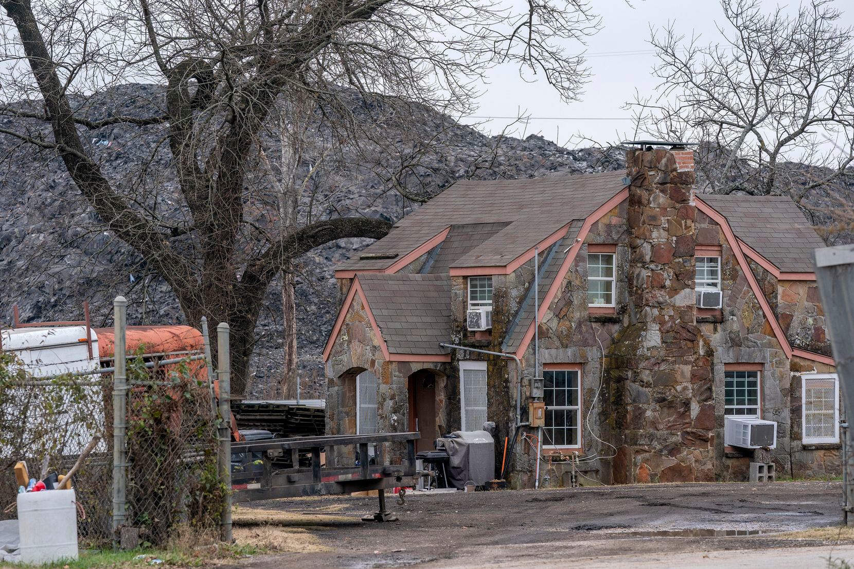 The pile of roofing shingles known as “Shingle Mountain” rises above a house, Tuesday,...