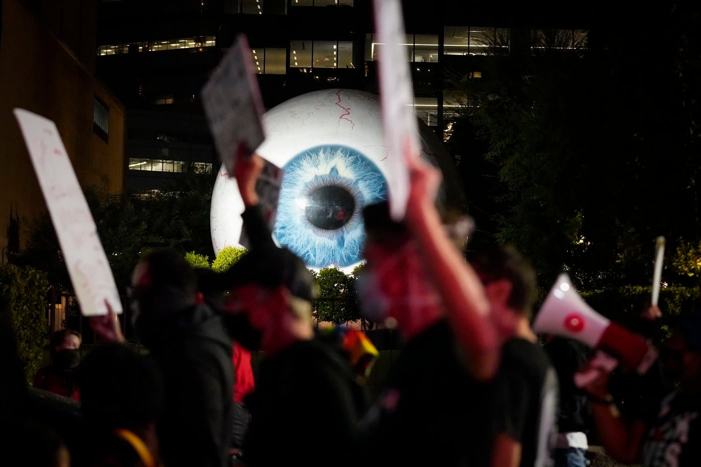 Demonstrators pass artist Tony Tasset’s giant eyeball sculpture, "Eye" on Main Street as they march in downtown Dallas after a Kentucky grand jury brought no charges against Louisville police for the killing of Breonna Taylor on Wednesday, Sept. 23, 2020.