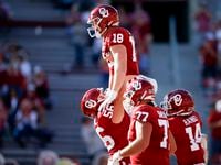 Oklahoma offensive lineman Creed Humphrey (56) lifts tight end Austin Stogner (18) after...