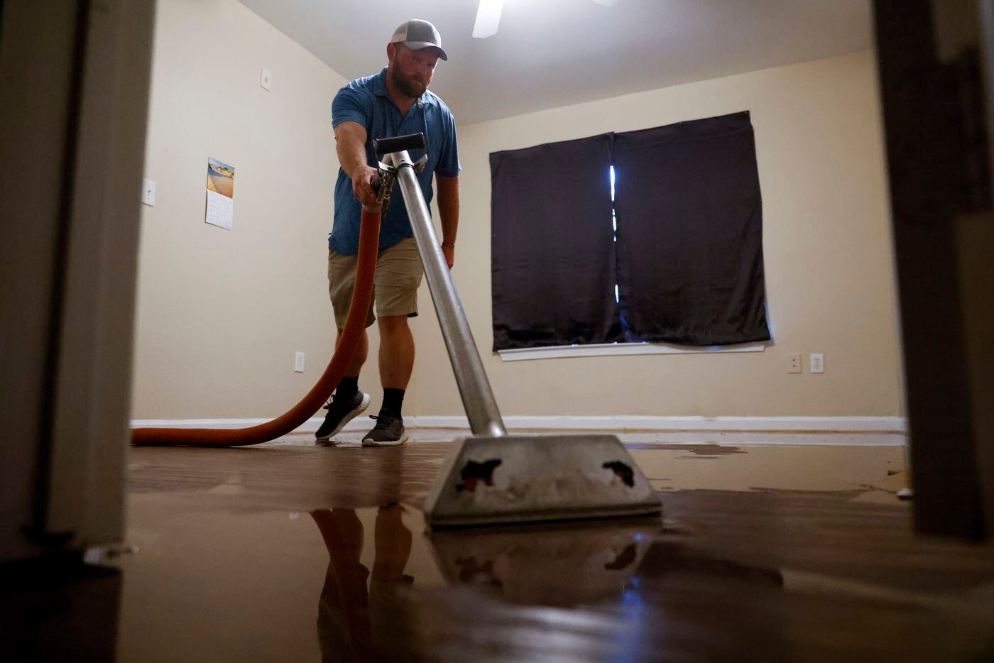 Jerry Owen, owner of Rez-CLN vacuums flood water collected in a house in Spring Oaks...