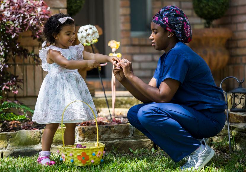 Emergency room doctor Gina Mullen helps her daughter, 2-year-old Gracie, hunt for Easter...