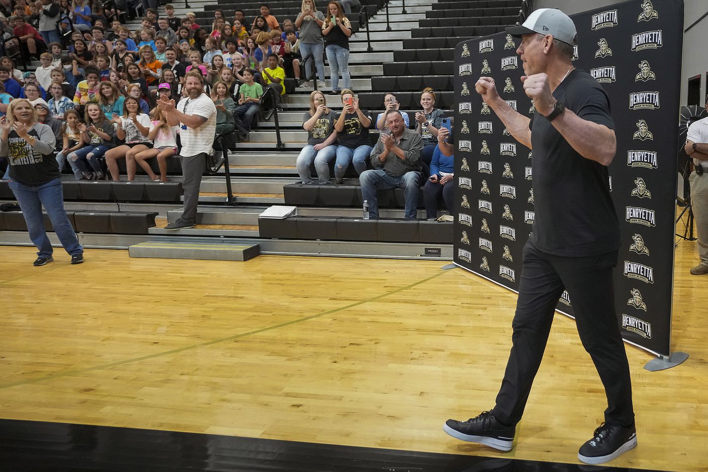 Troy Aikman walks into the gymnasium to surprise students during a pep rally at Henryetta High School.