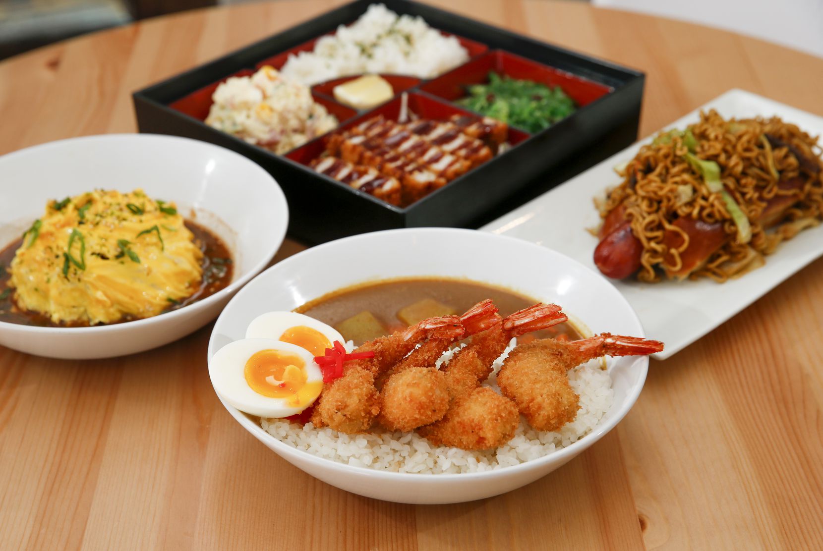 Shrimp katsu curry, front, omurice, left, yakisoba hottodoggu, right, and a tonkatsu bento...
