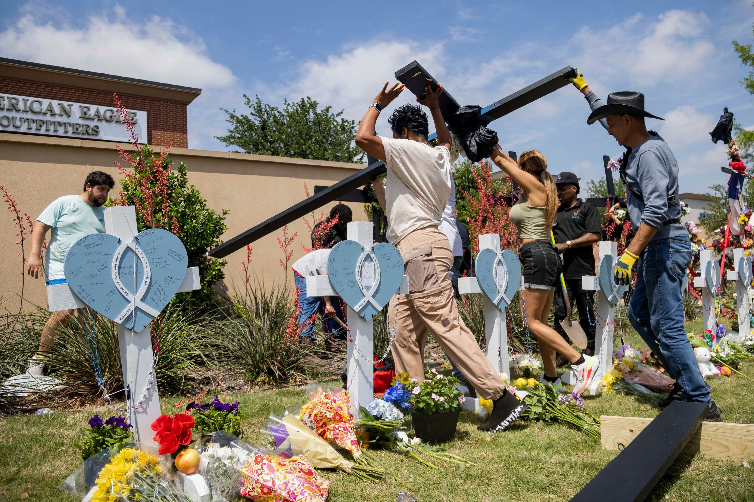 Black crosses are erected at a memorial outside the mall after a mass shooting at Allen...
