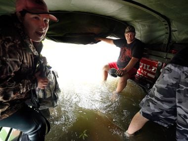 Christina Crump (left) reacts as flood waters rush into the bed of a military-type hauler...