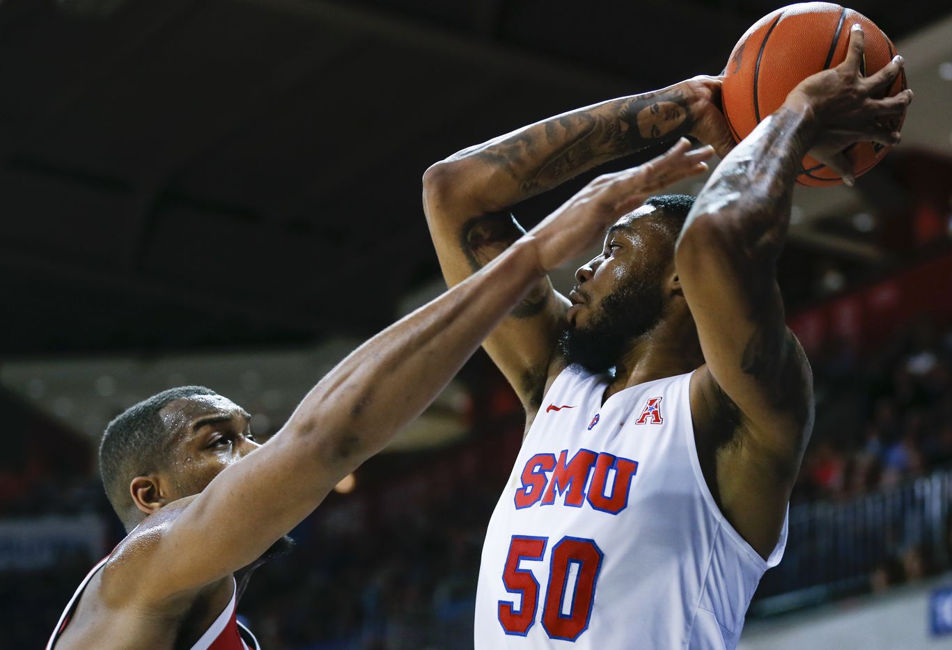 Southern Methodist Mustangs forward Marcus Weathers (50) keeps the ball from Houston Cougars...