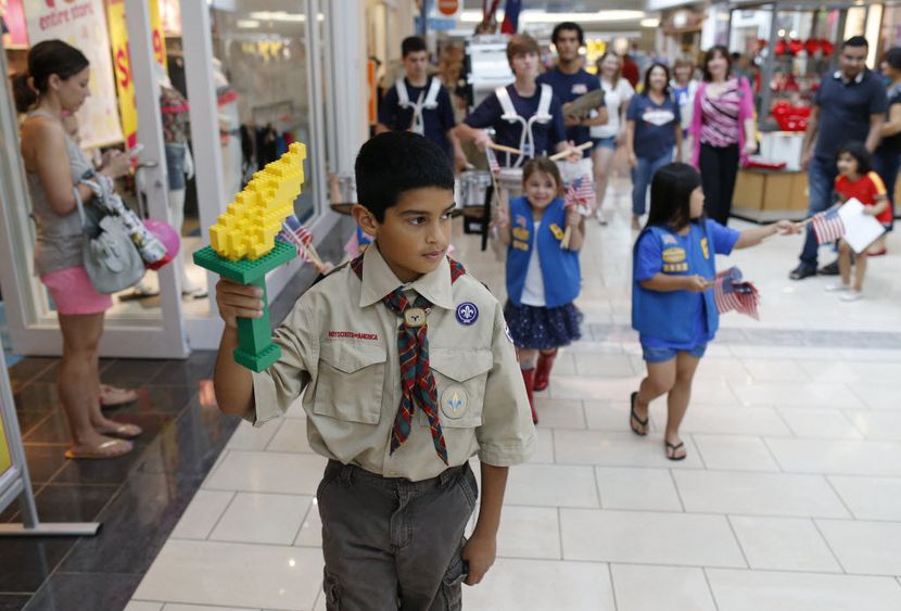 Ryan Alonzo, 10, of Carrollton holds a torch made of LEGO pieces marches in a parade with...