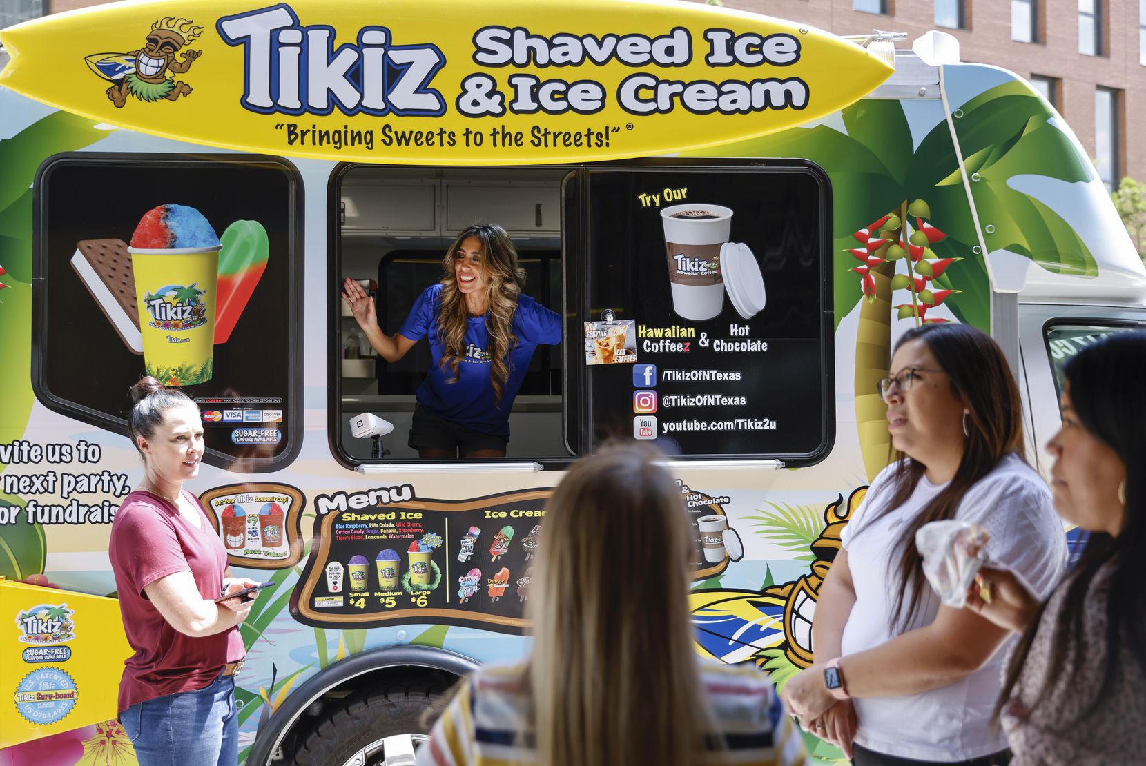 Gabriela  Ávila, propietaria de un camión de helados y raspados, toma pedidos de los...