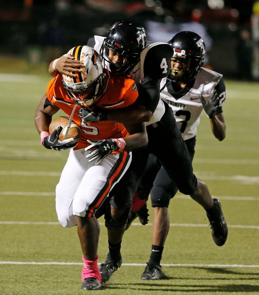 Haltom's Kenneth Cormier Jr. (5) is tackled by Euless Trinity's John Shead (4) after a first...