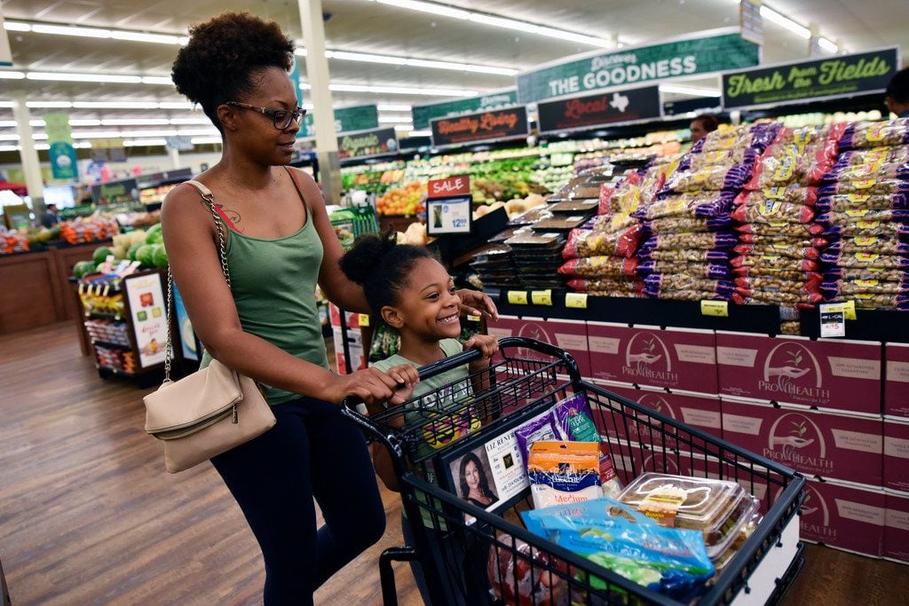 Quannesia Thomas and Nailah Hill, 5, shop the produce and bakery sections inside the...