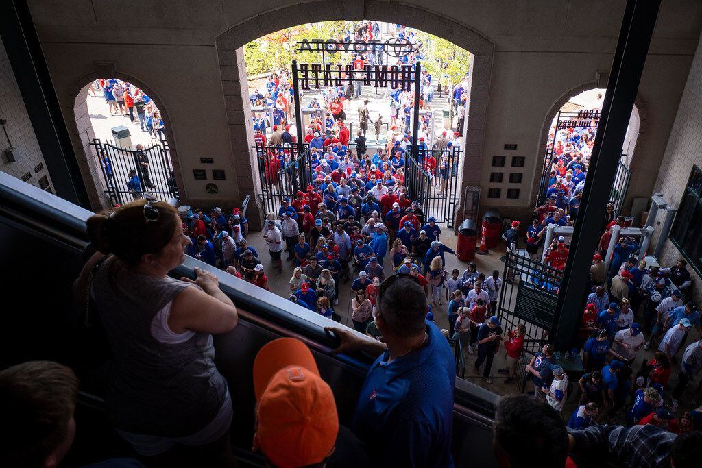 During the second inning fans wait in long lines to go through security and enter the...