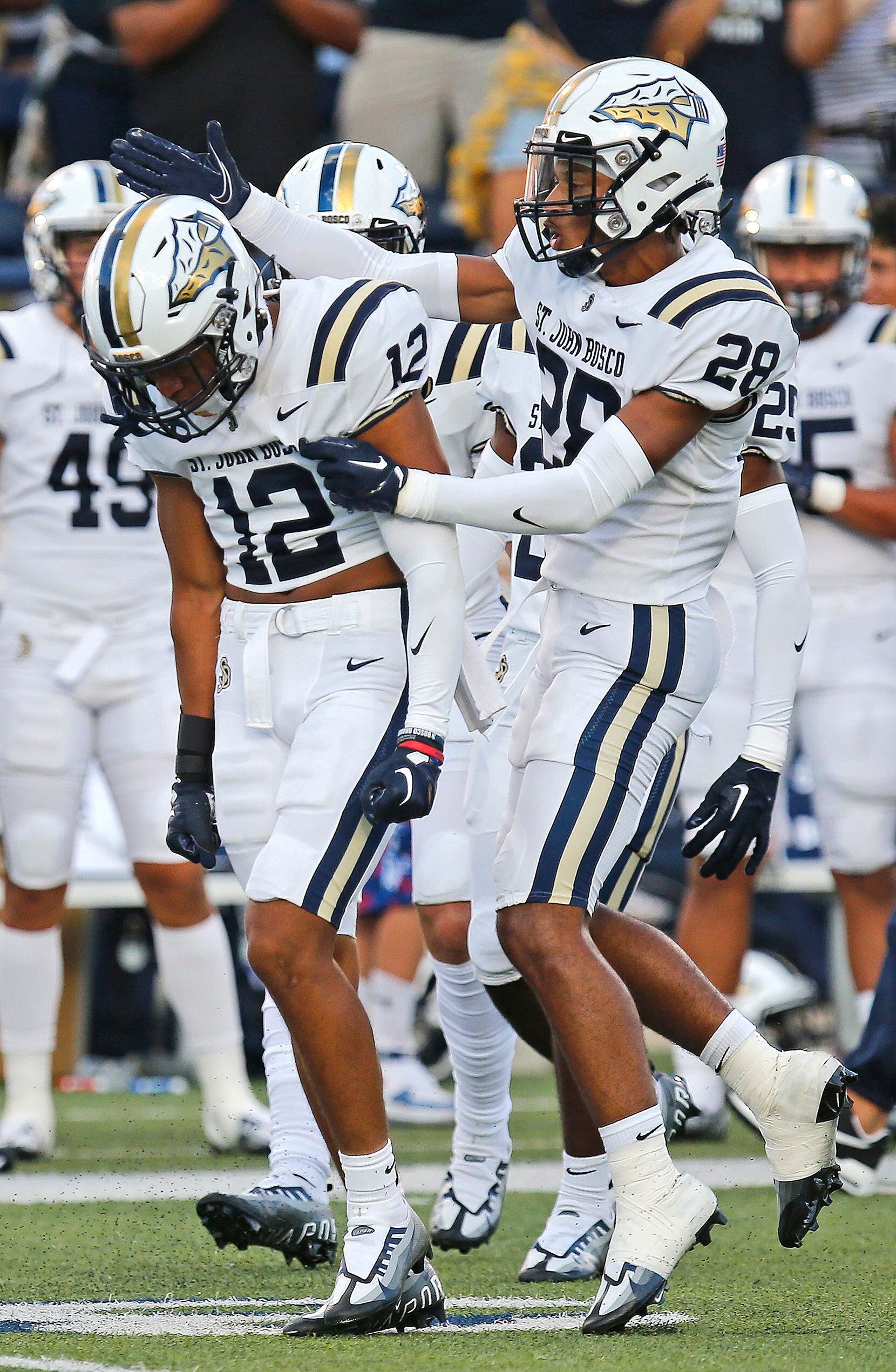 St. John Bosco High School defensive back Jshawn Frausto-Ramos (12) is congratulated by St....