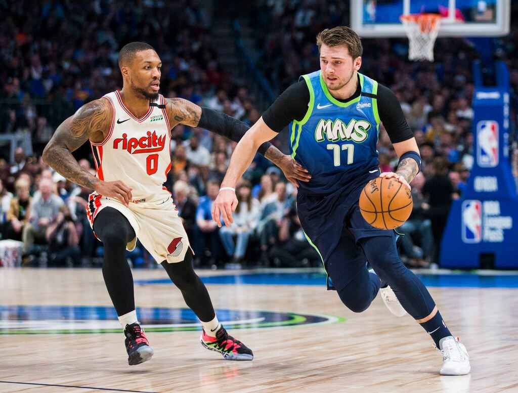 The Dallas Mavericks' Luka Doncic (77) drives against the Portland Trail Blazers' Damian Lillard (0) during the first quarter on Friday, Jan. 17, 2020, at American Airlines Center in Dallas.