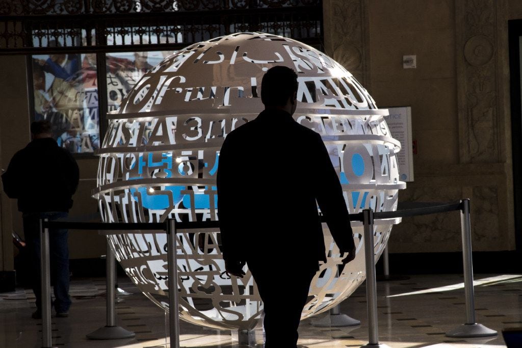 A customer walks past a statue in AT&T's flagship store in San Francisco. The Dallas-based...