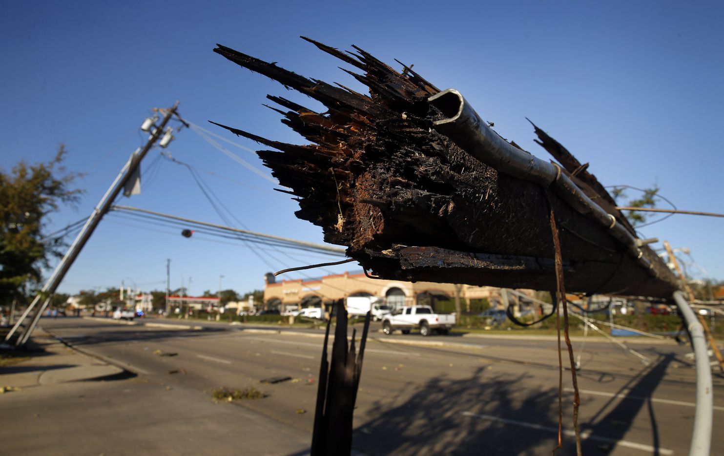 A sheared off utility pole lays over Preston Rd in Dallas near the Preston Royal shopping center Monday, October 21, 2019. A tornado tore through the entire neighborhood knocking down trees and ripping roofs from homes and businesses.