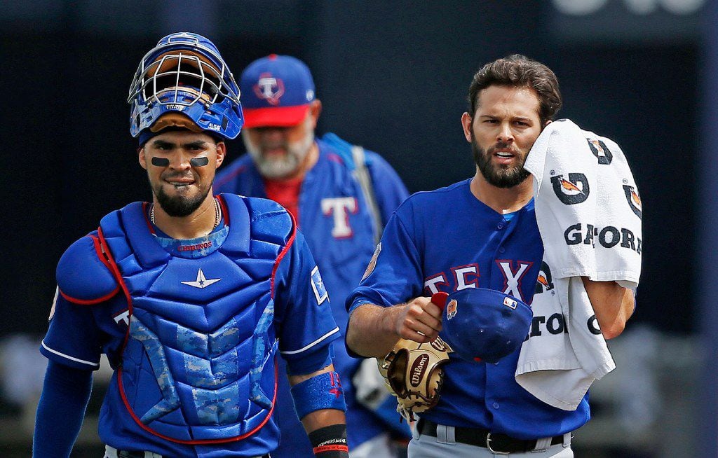 Texas Rangers starting pitcher Nick Martinez, right, walks in from the bullpen with catcher...