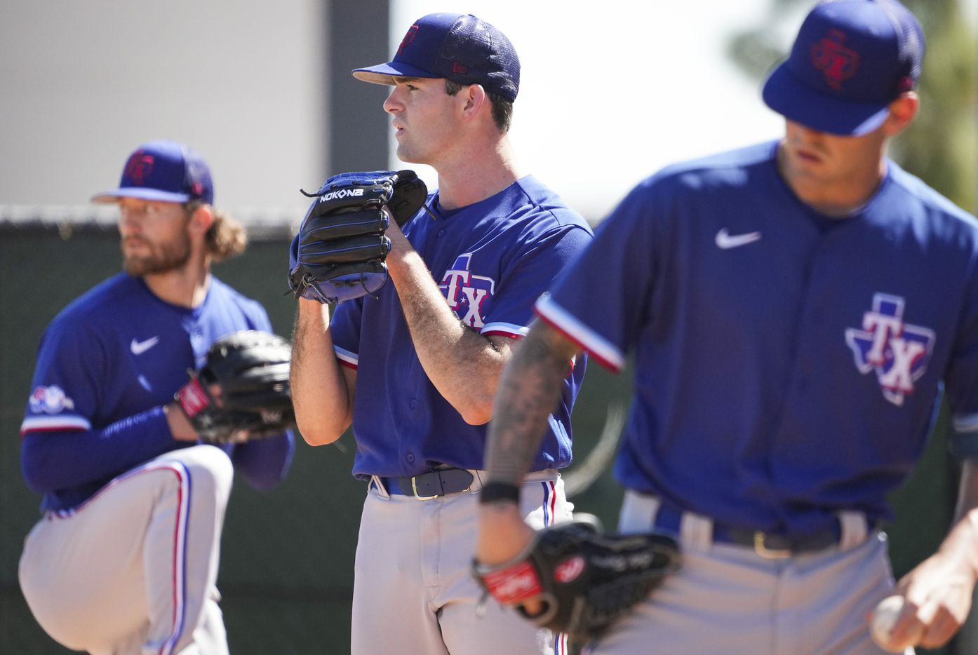 Texas Rangers pitchers Cody Bradford (center), Jake Latz (left) and Cole Ragans (right) work...