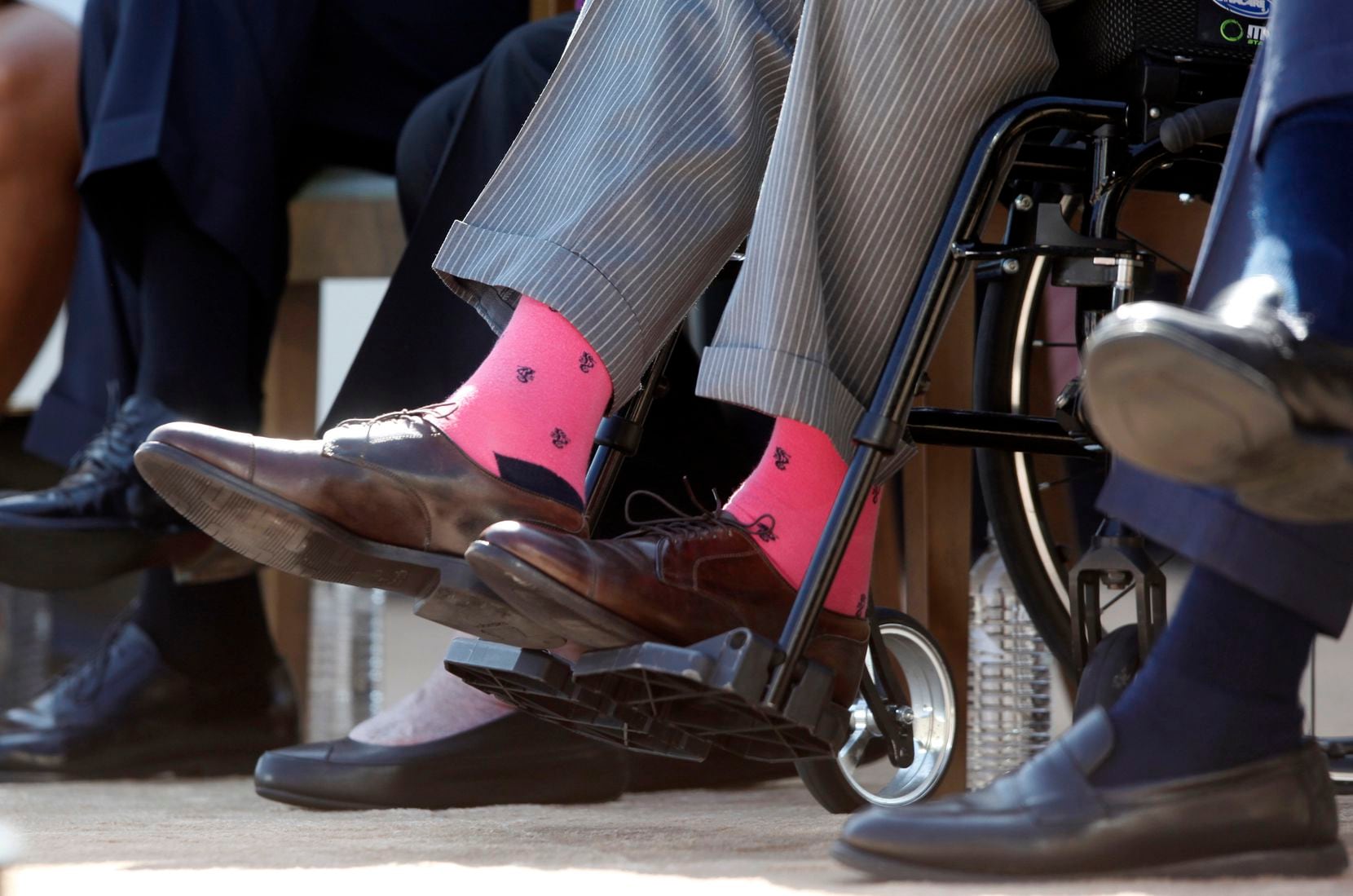 2013: Former President George H.W. Bush wears pink socks as he is seated in a wheelchair at...