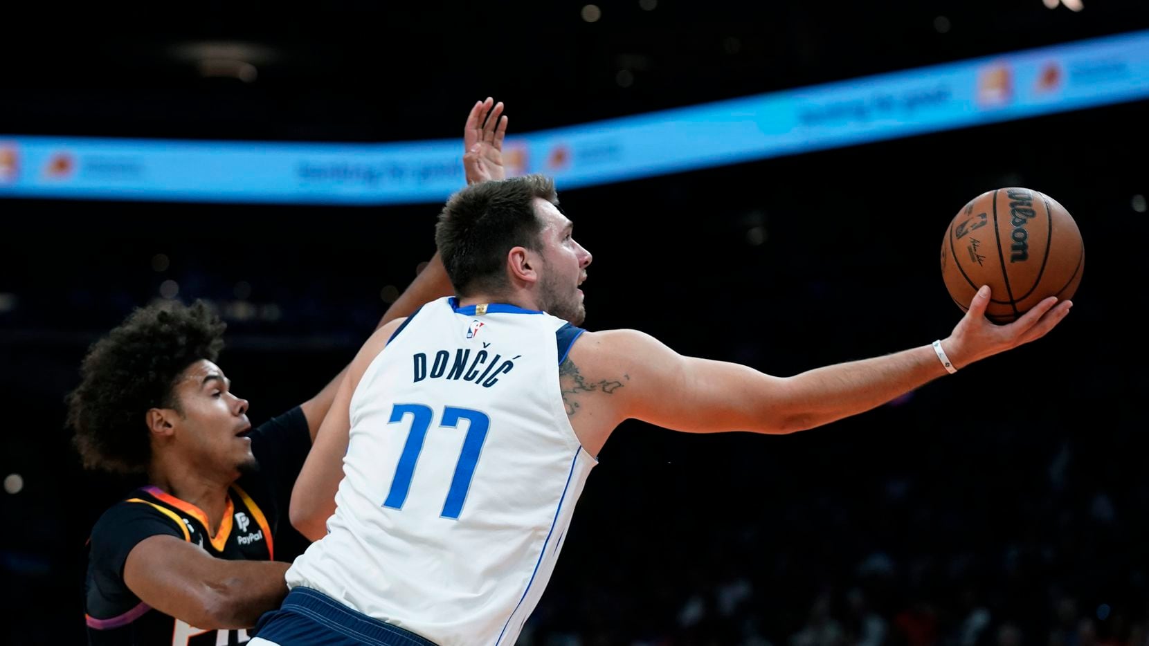 Dallas Mavericks guard Luka Doncic (77) drives past Phoenix Suns forward Cameron Johnson to...
