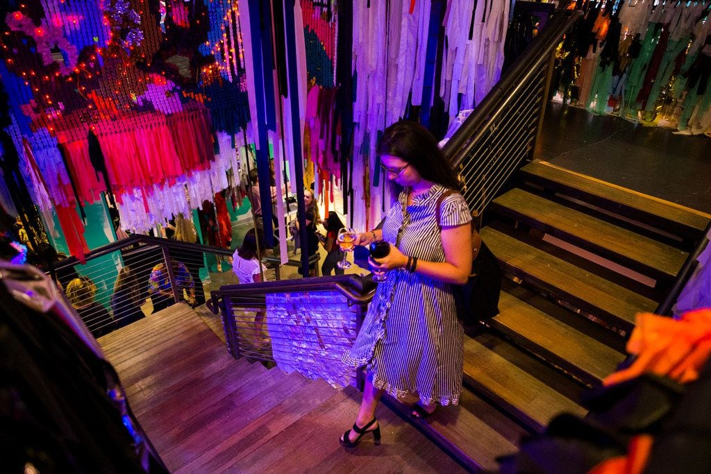 A woman walks down a staircase adorned with artwork by The Color Condition inside a new...