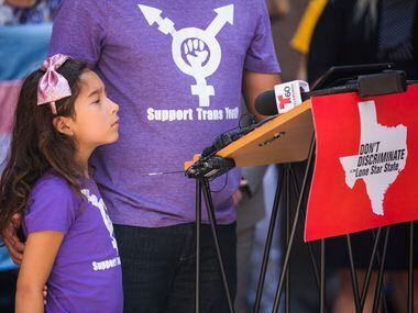 Libby Gonzales, 7, who is transgender, stands with her father, Frank Gonzales, as he speaks...