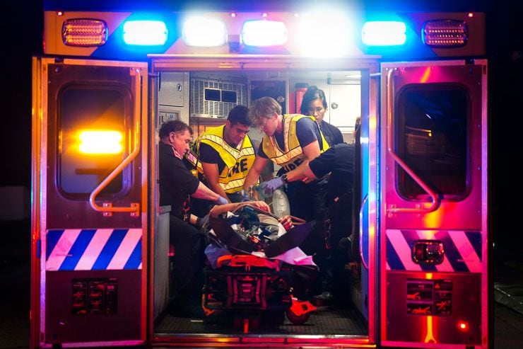 Paramedics treat a patient in the back of an ambulance.