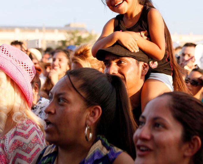 A young girl sits on the shoulders of her father during a Fiestas Patrias festival. 