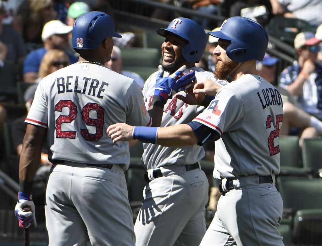 Texas Rangers' Elvis Andrus, center, is greeted by Adrian Beltre (29) and Jonathan Lucroy,...