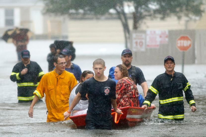 Voluntarios del Departamento de Bomberos y Rescate County Road 143 ayudan a rescatar a...