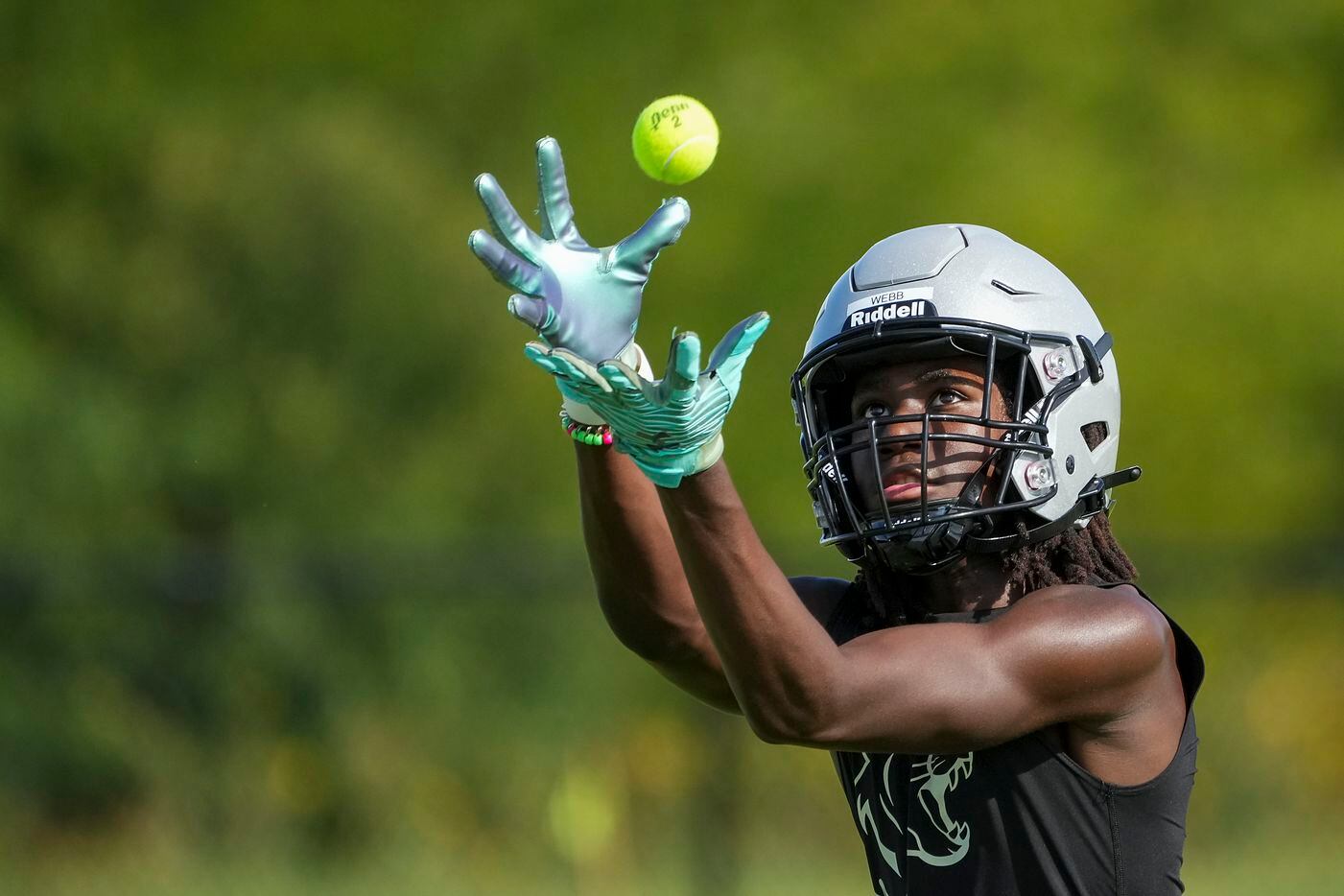 Wide receiver Donovan Webb reaches for a tennis ball as players run drills during the first...