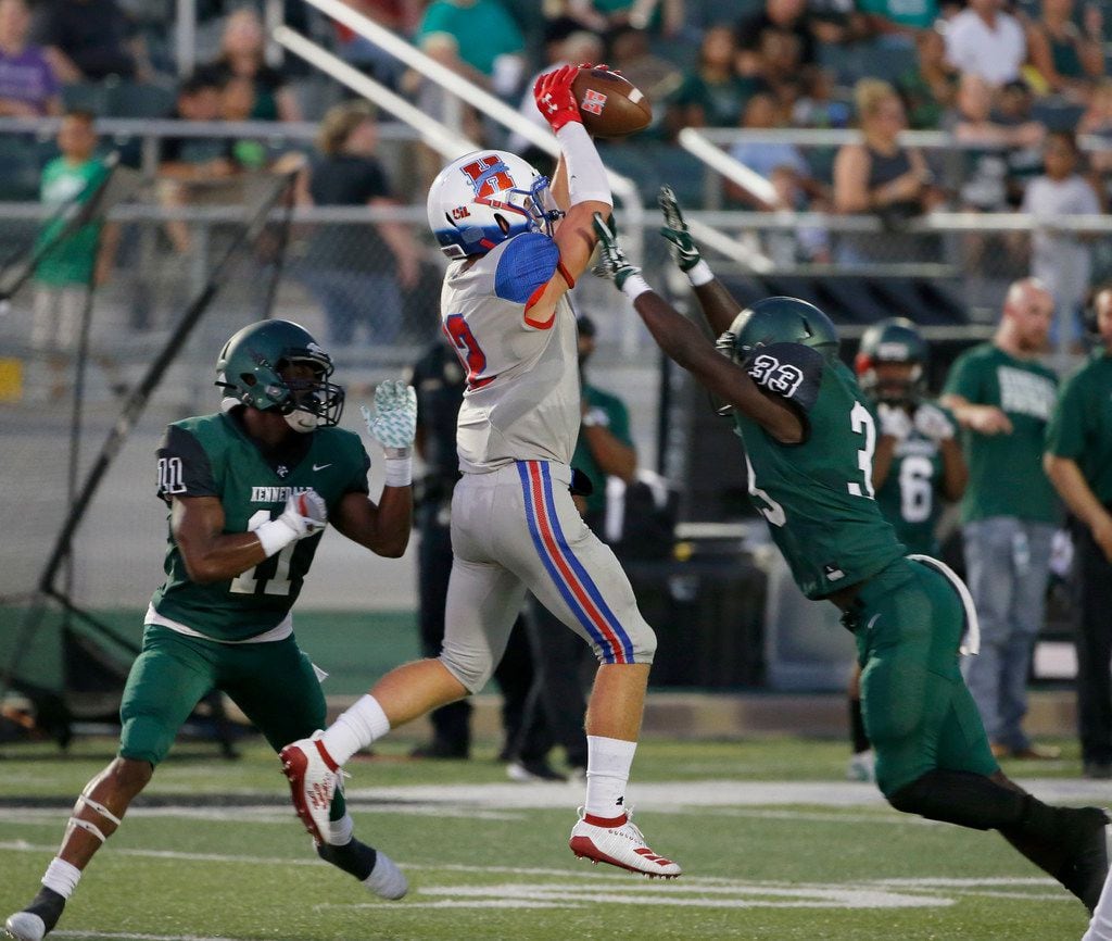 Midlothian Heritage receiver Haydon Wiginton (12) catches a pass between Kennedale defenders...