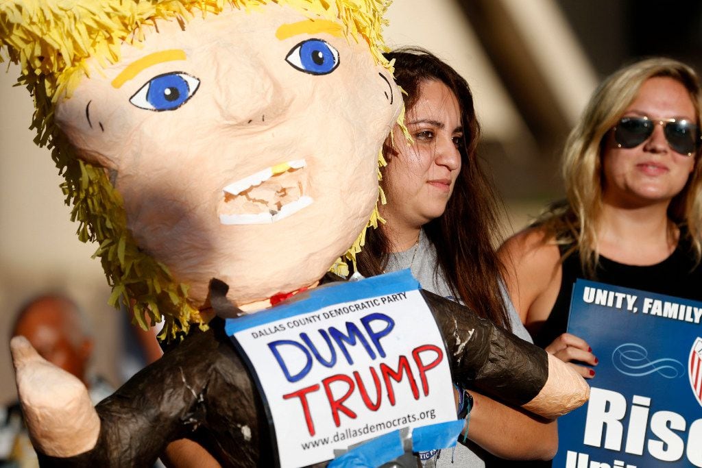 Carmen Ayala holds up a Donald Trump pinata during a support rally for DACA recipients at City Hall Plaza in Dallas on Wednesday. 