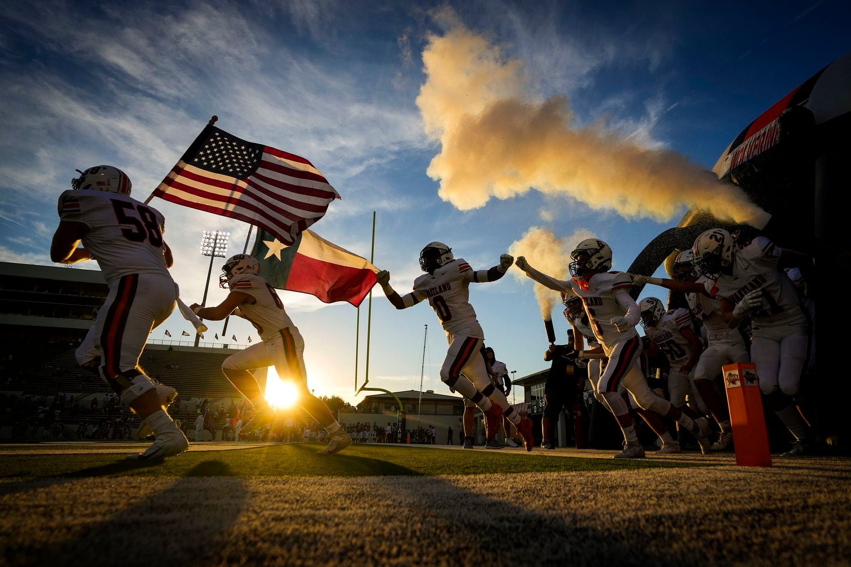 Frisco Wakeland offensive linemen Cade Myer (58) and Jack Jones (60) carried flags as they lead their team onto the field to face Denton Ryan in a District 5-5A high school football game Sept. 23 at the C.H. Collins Complex in Denton. 