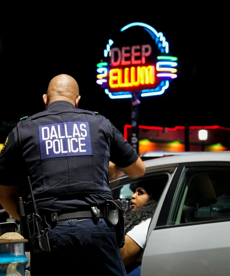 Dallas police patrol a parking lot, checking on people in parked cars, in Deep Ellum on...