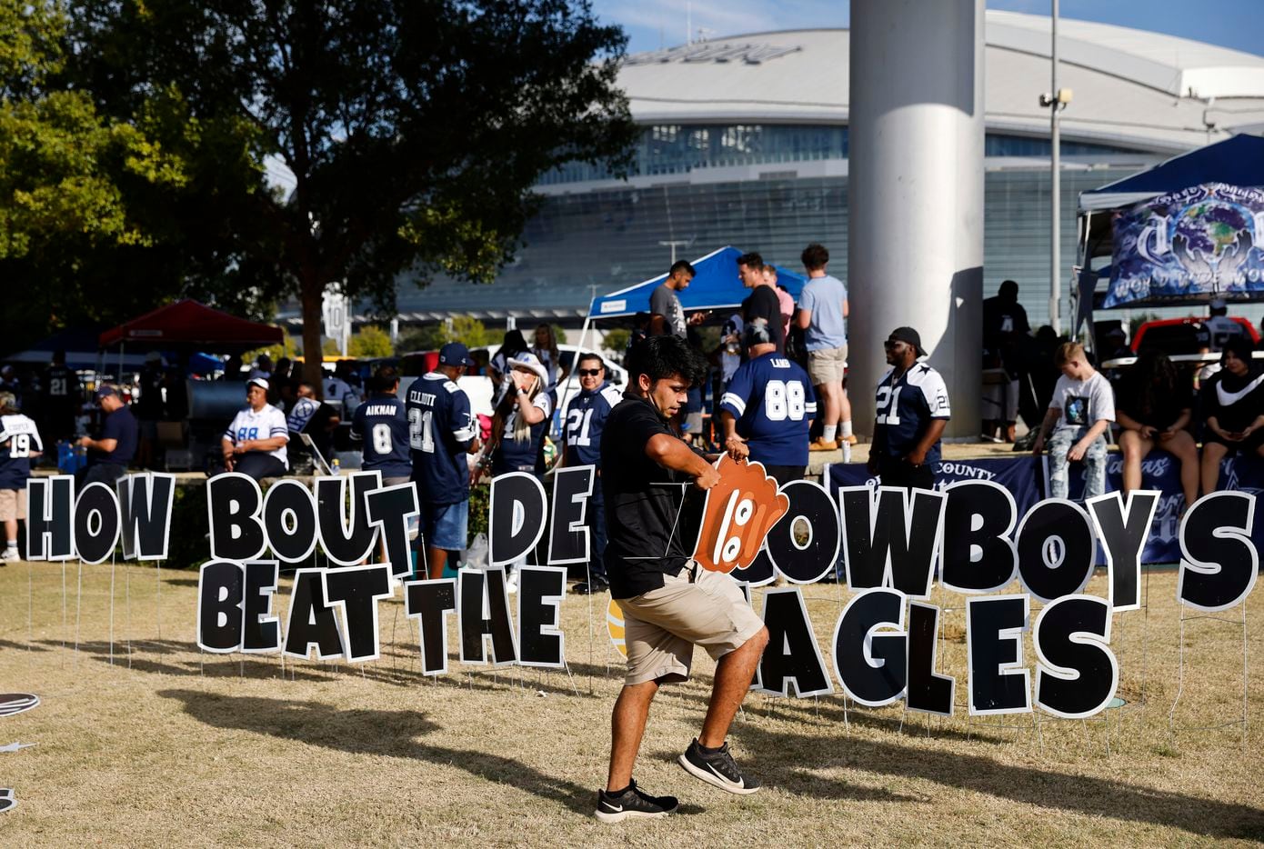 Dallas Cowboys fan Alex Perez of Dallas constructs a game day 'yard sign' display outside of AT&T Stadium in Arlington, Monday, September 27, 2021. He says he puts one up for every home opener. This one reads, How Bout Dem Cowboys, Beat The Eagles'. (Tom Fox/The Dallas Morning News)