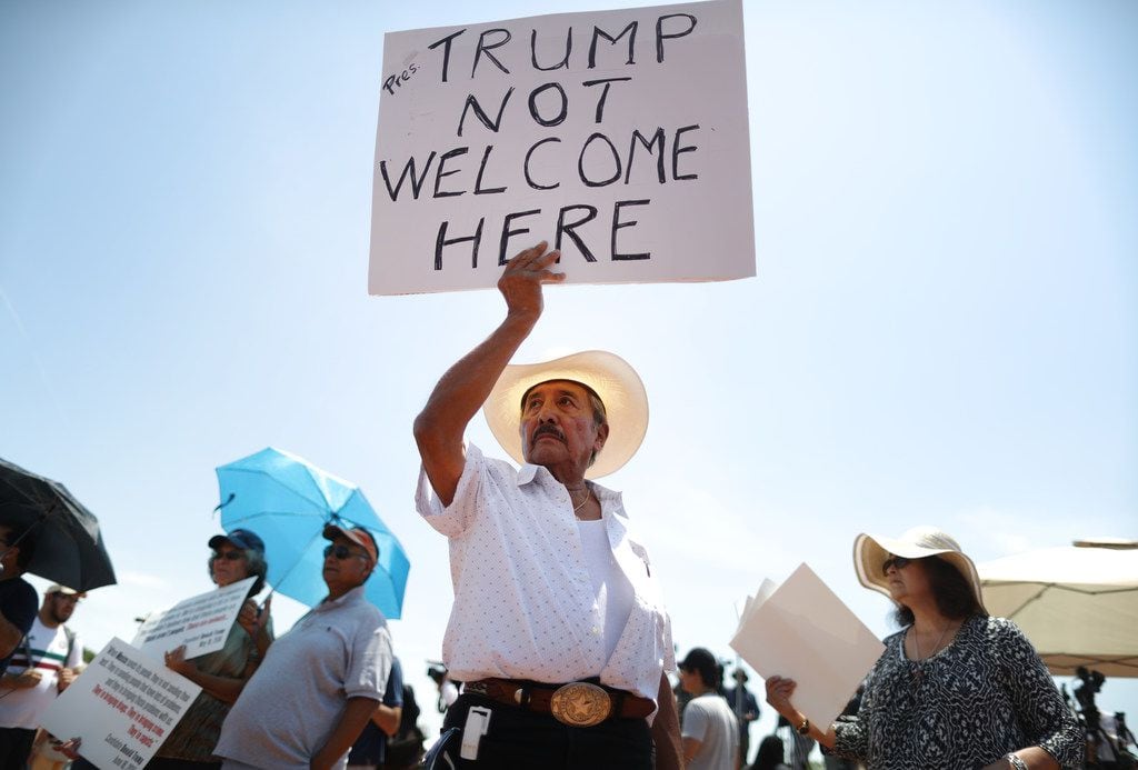 Miguel de Anda, born and raised in El Paso, holds a sign reading 'Trump Not Welcome Here' at a protest against Trump's visit to El Paso following the mass shooting there.