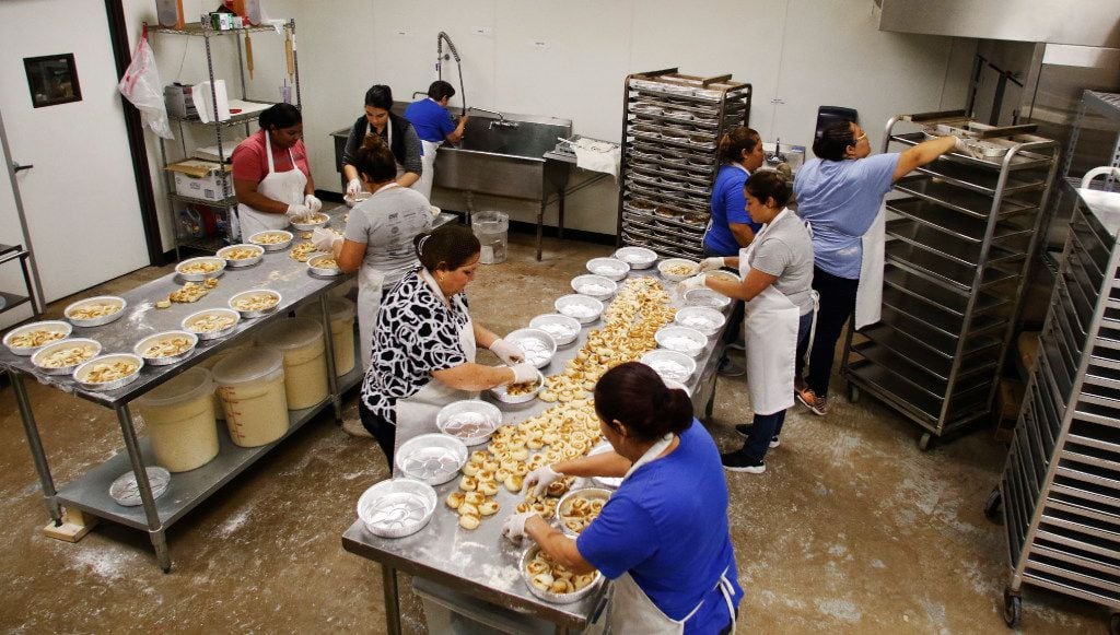 Lorena Garcia (center) and Eglantina Nunez (top in blue)  and others make freshly baked...