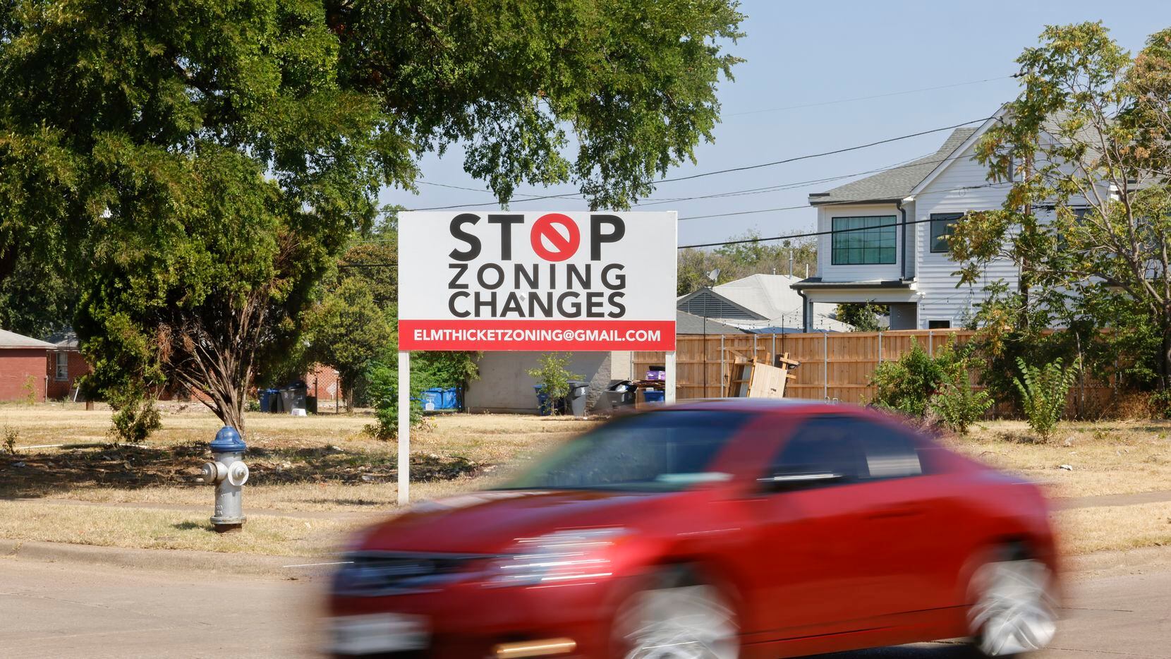 Traffic pass by a sign displaying words against zone changes along Roper St on Wednesday,...