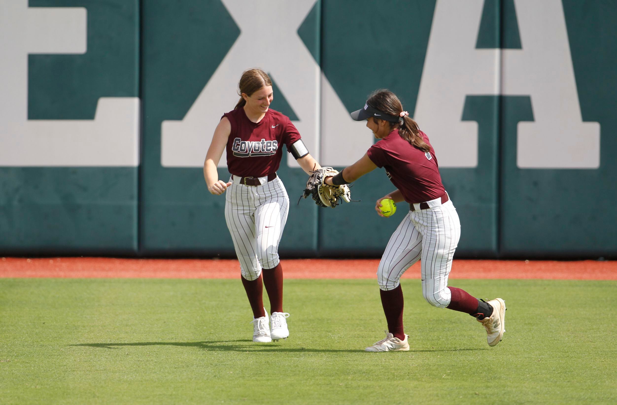 Frisco Heritage outfielders Allie Crow (11), left, and Vyanna Quezada (7) touch gloves after...