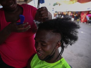 Jean Rodmique, 32, from Haiti, sits on a chair while his wife braids his hair, Wednesday, September 29, 2021, in Monterrey, Mexico.