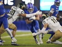 Air Force running back Brad Roberts, center, is stopped after a short gain by Colorado State...
