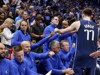 Dallas Mavericks guard Luka Doncic (77) receives first bumps from coaches before facing the...