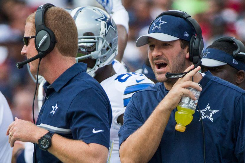 Dallas Cowboys quarterback Tony Romo yells toward head coach Jason Garrett on the sidelines...