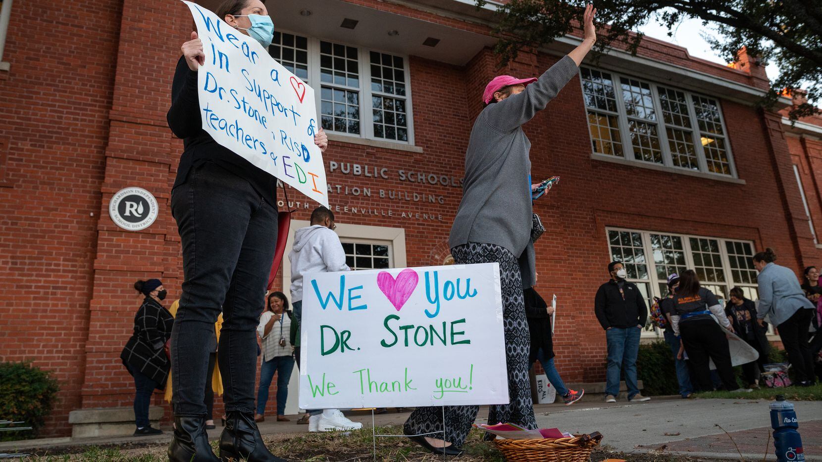 Ellen Alexandrakis, left, and Lowry Manders stand while holding signs in support of RISD...